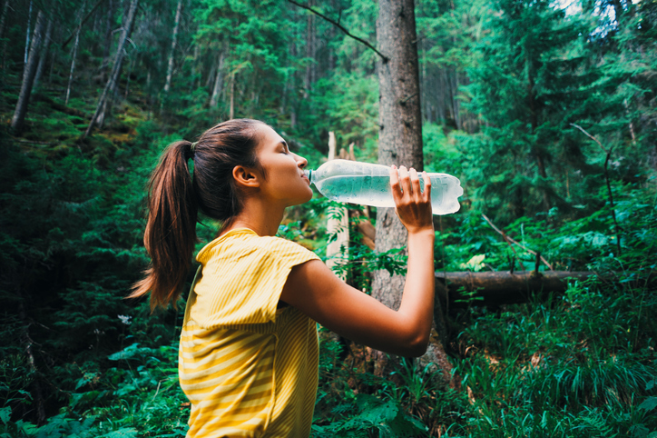Jeune Femme Avec Une Bouteille D'eau à L'extérieur En Chuchotant Quelque  Chose